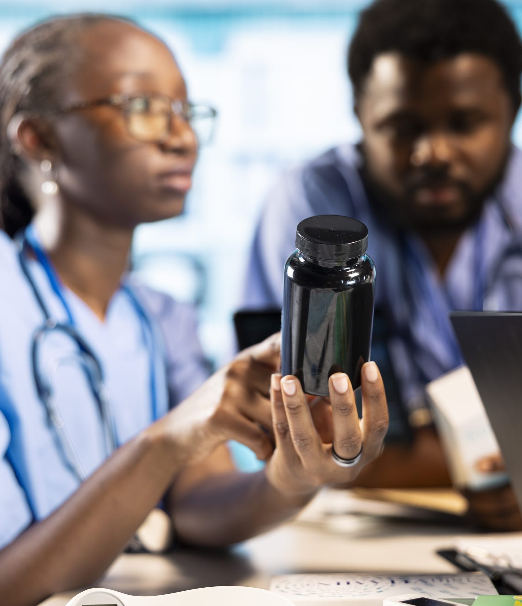 Physician and medical assistants in a clinic office discussing about drugs and painkillers to recommend to patients, providing accurate expert advice. Improving the medical services.